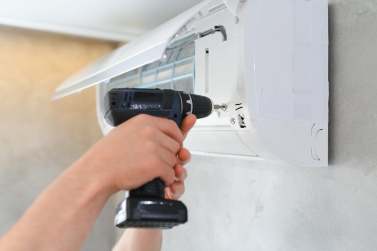 specialist cleans and repairs the wall air conditioner