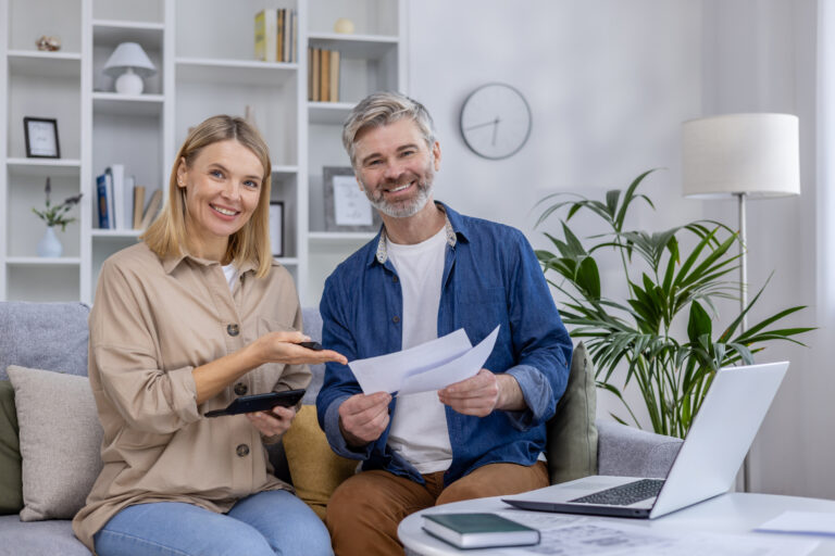 Mature couple discussing finances with laptop and documents