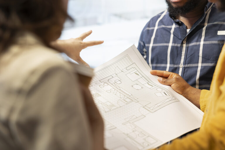 Business development team reviewing architectural plans for a high class office